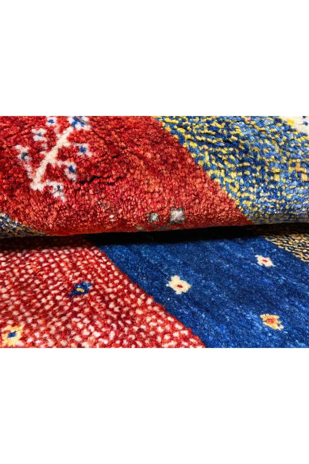 Gabbeh rug 156x101 cm close-up: coarse woven texture in red and blue