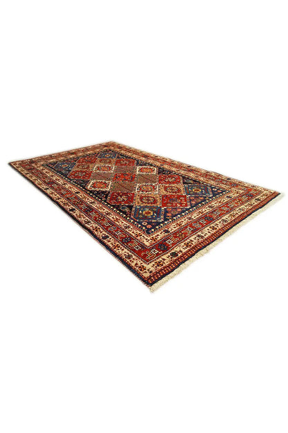 Rectangular oriental rug with a blue-and-red diamond pattern and decorative border