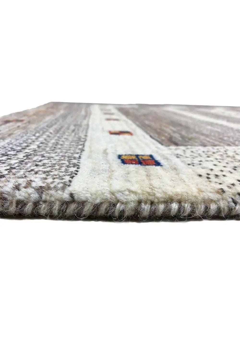 Gabbeh rug edge view: light surface, colorful cartridges, short fringes