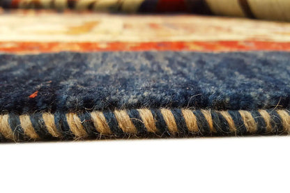 Oriental rug edge with fringe, dark border strip on a blue and cream-colored pattern