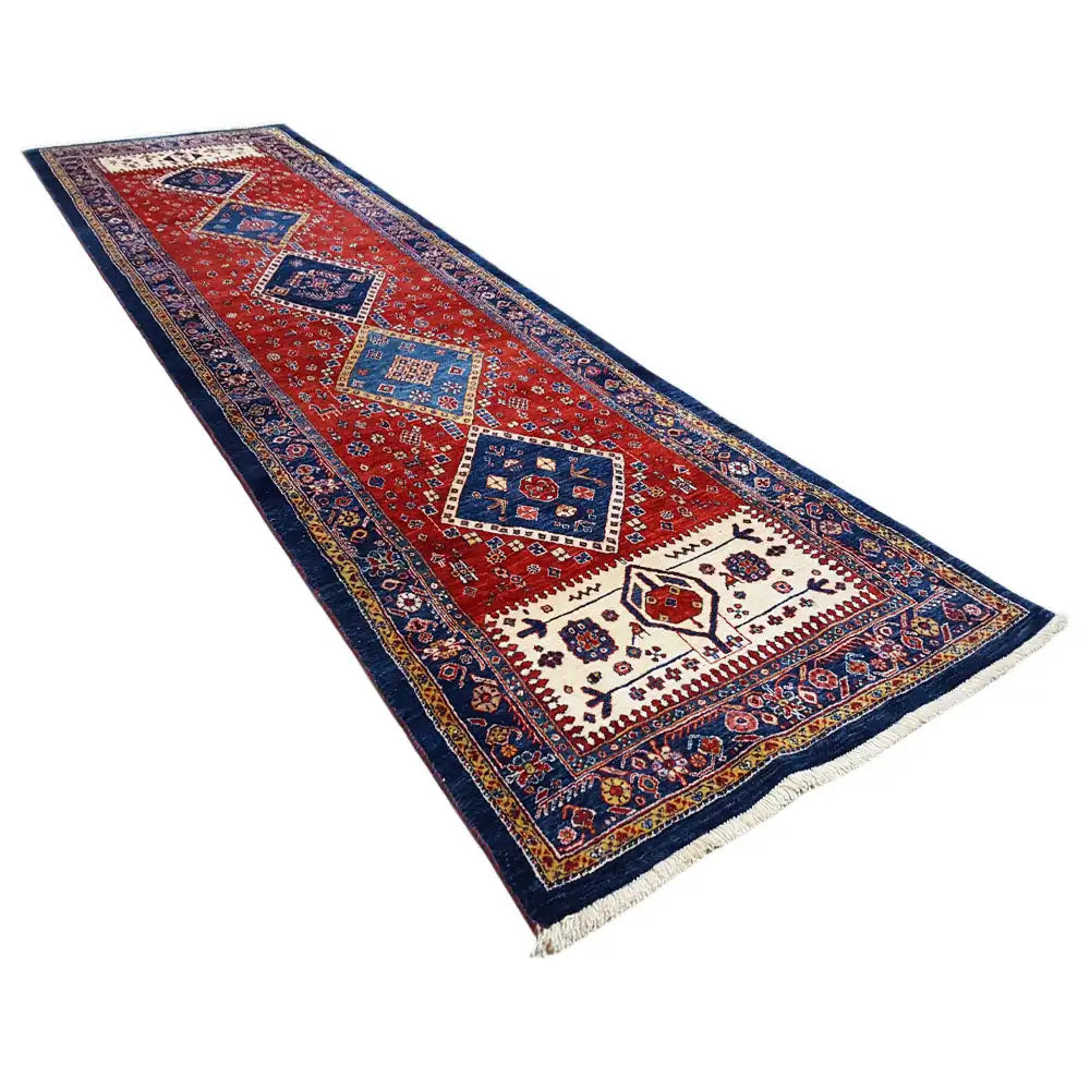 Runner rug with a red field, dark blue borders, and central diamond patterns