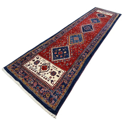 Oriental rug runner with a red background, dark blue medallions, and white ornamental detailing