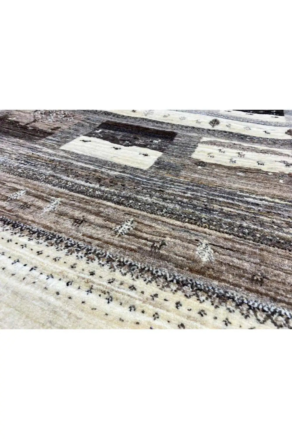 Rug detail: woven stripes and small ornaments in beige, gray, and dark brown