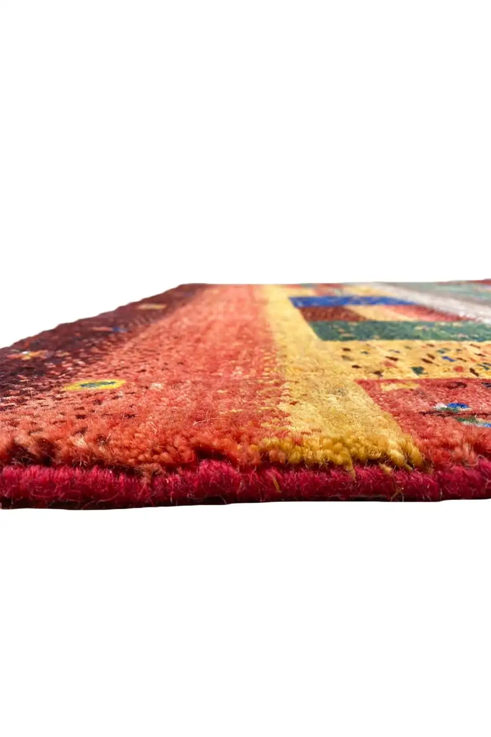 Corner of a Gabbeh rug with a dense red pile and yellow-blue patterned areas.