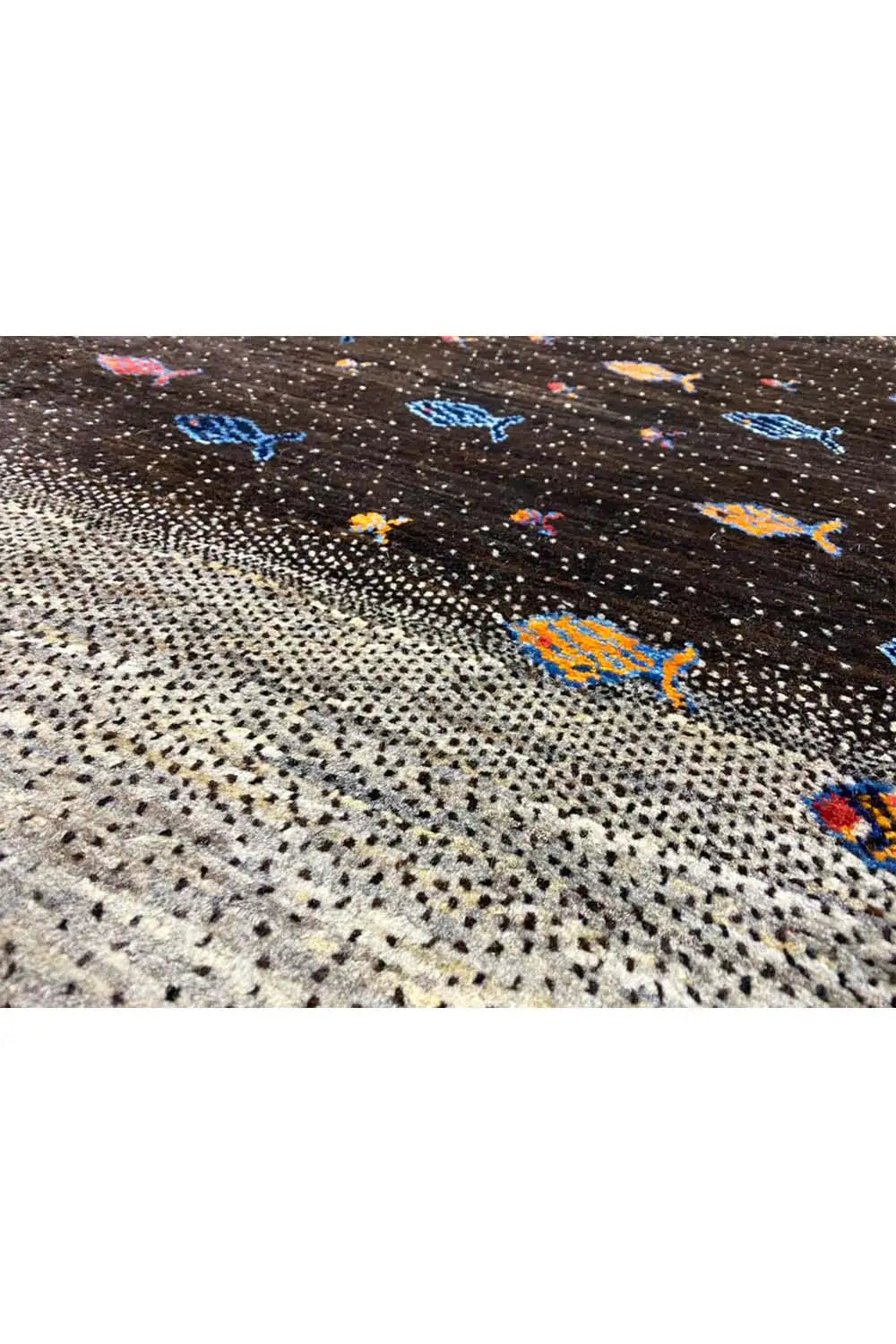 Close-up of a Gabbeh rug: black-and-gray woven texture with colorful fish motifs