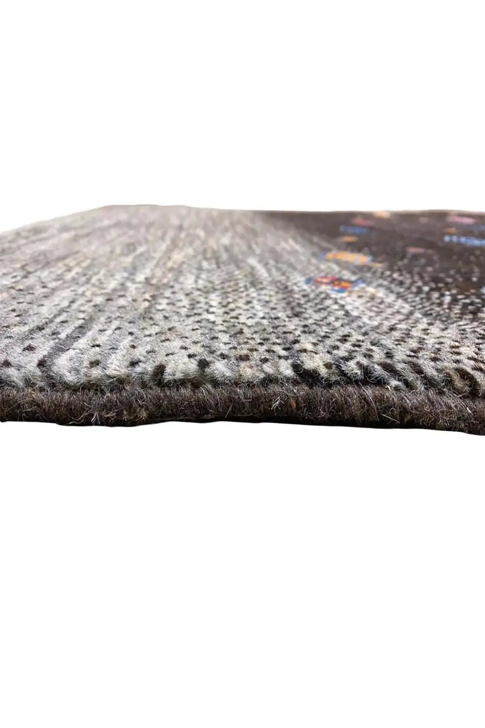 Gabbeh rug edge view: gray area, black patterned section, visible selvedge
