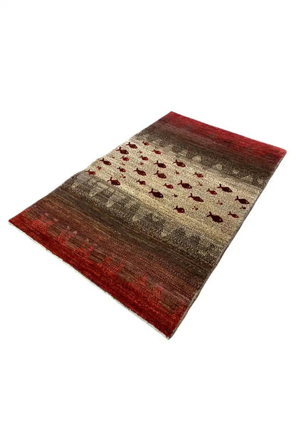 Gabbeh rug, red-and-beige patterned surface with red fish motifs, spread out diagonally