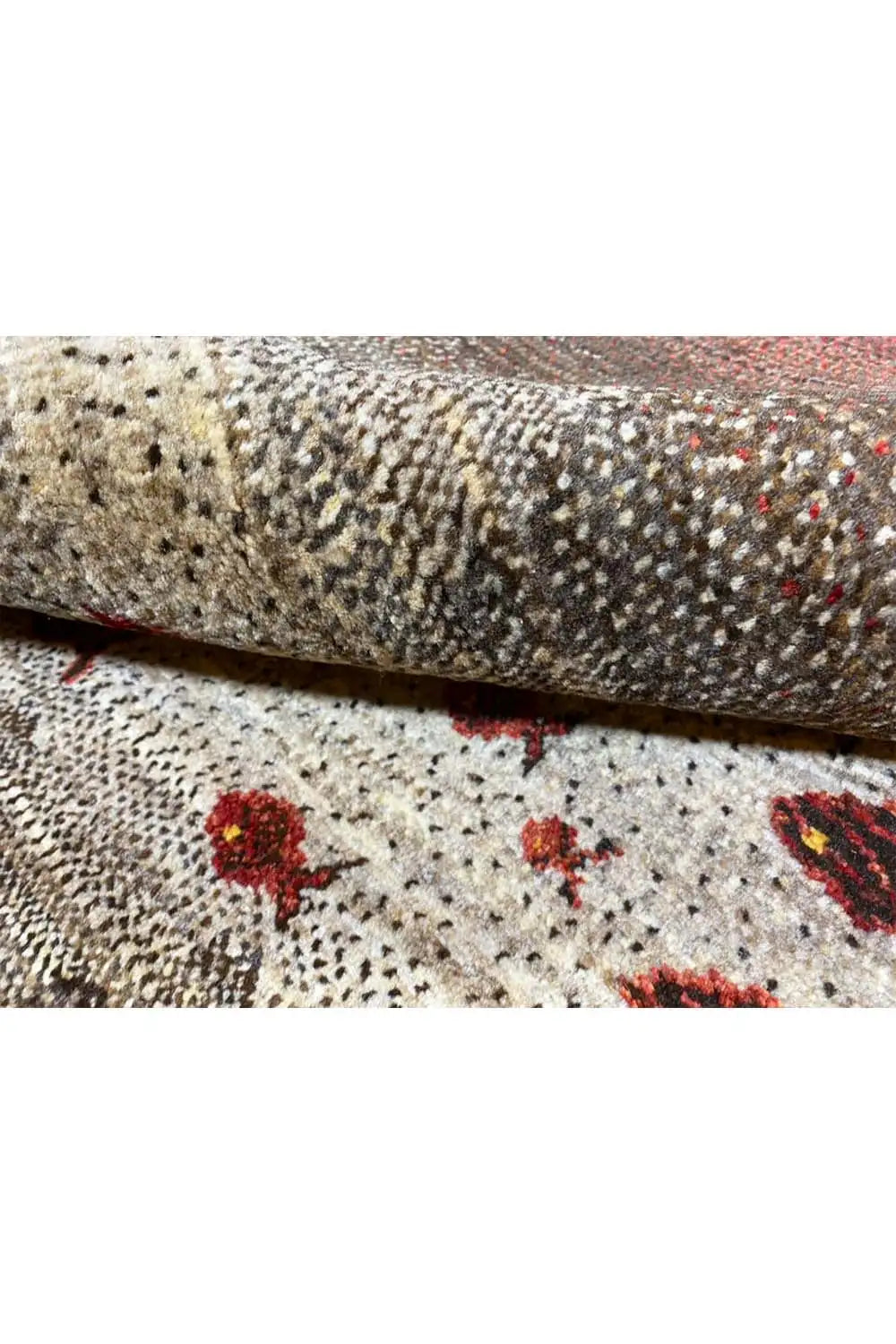 Close-up of a Gabbeh rug, beige texture with red fish motifs and a dense woven texture