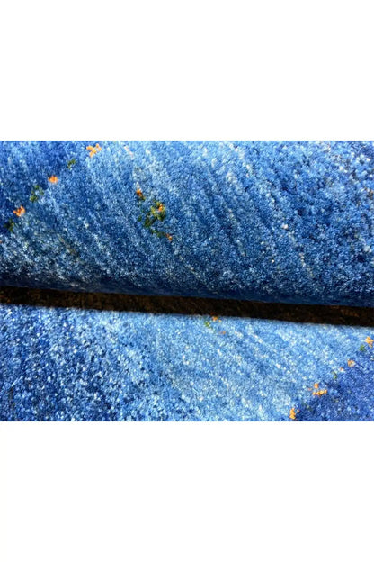 Blue Gabbeh rug pile with a blue striped pattern and small colored dots