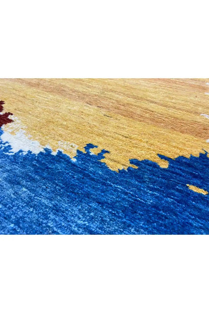 Close-up of a Gabbeh rug: blue area with a yellow-brown patterned section