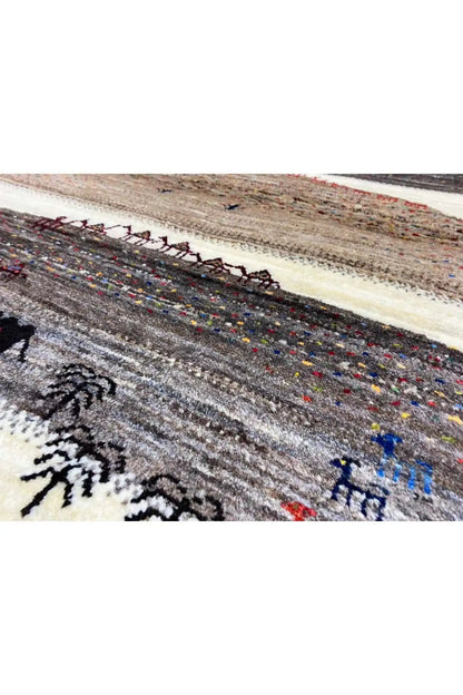 Gabbeh rug (132x84 cm) detail view: dark border with colorful accents and figures