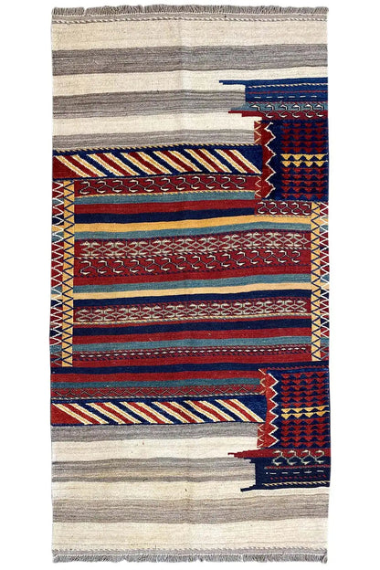 Rectangular kilim rug with a striped pattern in gray, blue, and red, with fringes.