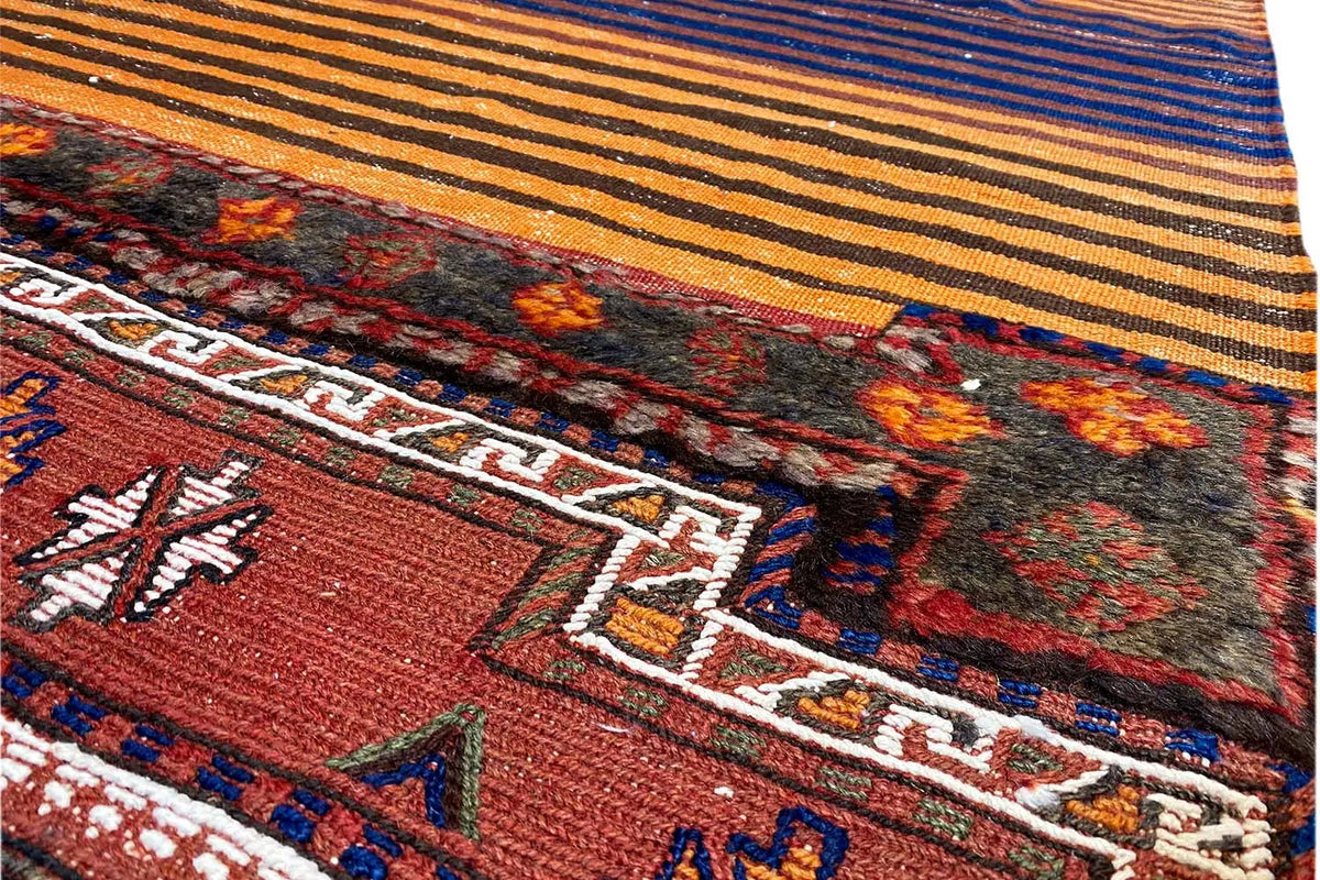 Bakhtiari rug with a geometric pattern, shades of red and blue, and orange-yellow stripes