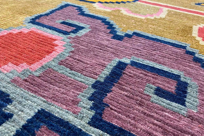 Designer rug with purple, blue, and red geometric shapes on a beige background