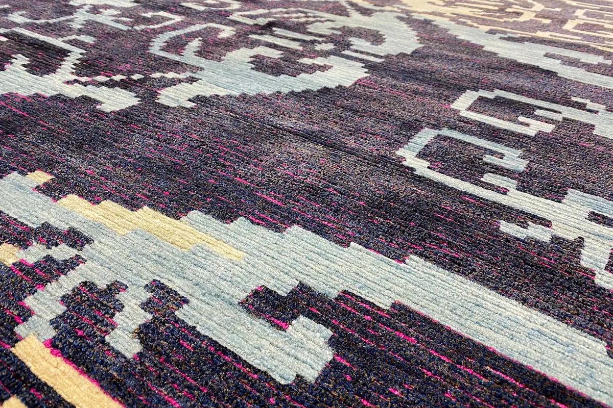Carpet detail with a dense woven pattern, dark blue, cream, and pink color fields