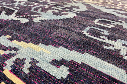 Carpet detail with a dense woven pattern, dark blue, cream, and pink color fields