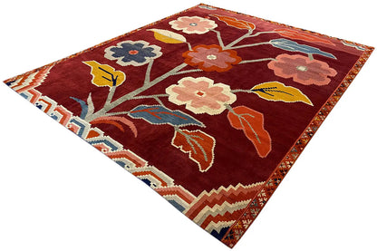 Designer rug Bo Hamsa, 304x253 cm: red rug shown from the corner with flowers, birds, and a border