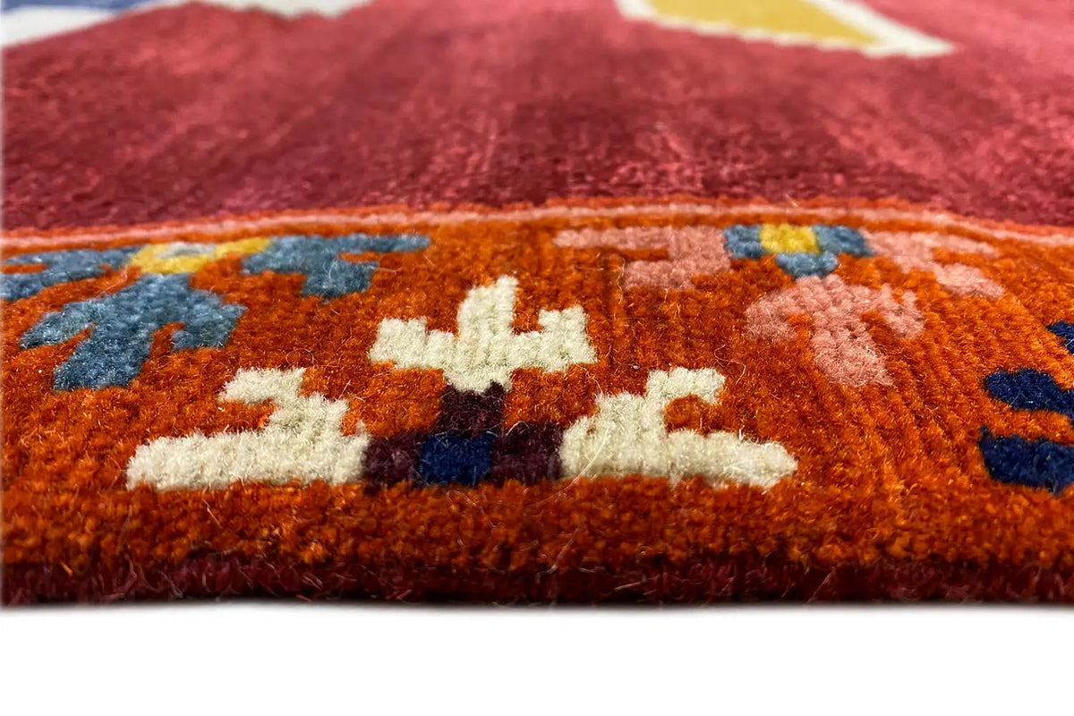 Designer rug Bo Hamsa: pile detail, red-orange base with multicolored floral patterns