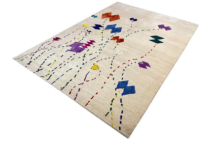 Beige designer rug with an abstract pattern in purple, blue, yellow and red