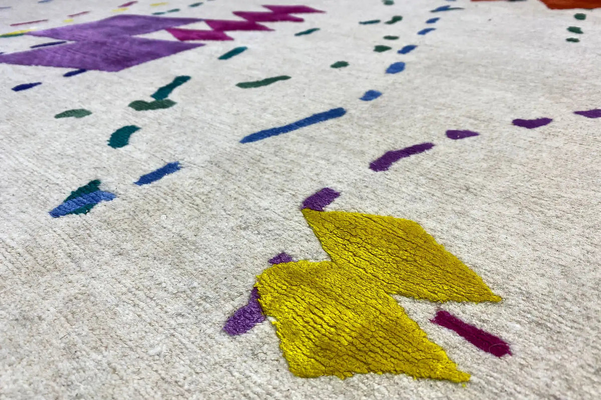 Close-up: beige carpet with a yellow paint stain and colorful lines
