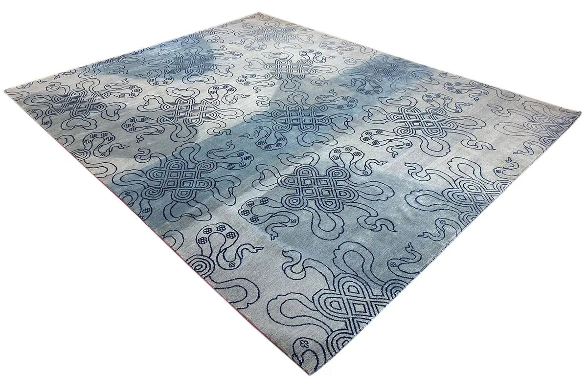 Designer rug with a Bo-Hamsa pattern in blue and light gray, corner view