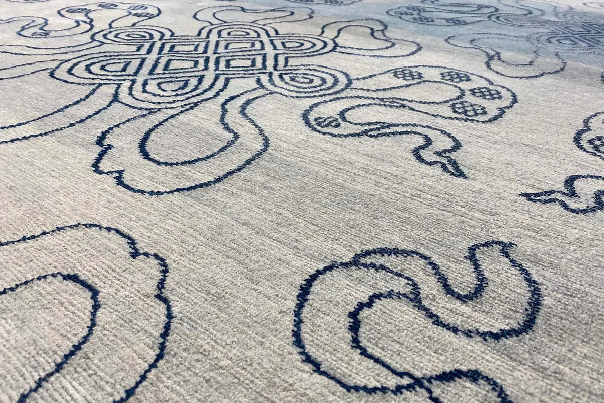Designer rug Bo-Hamsa: close-up of the blue woven ornamental pattern on light gray