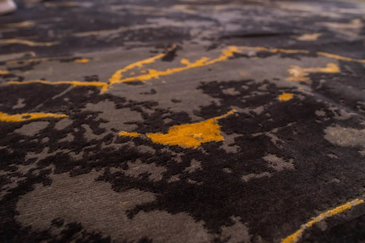 Close-up: dark gray carpet surface with yellowish marble-like lines