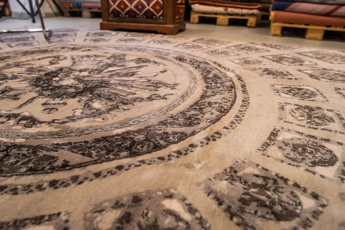 Close-up of a carpet: central medallion and border ornaments in beige/dark gray