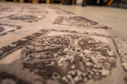 Close-up of a rug with a decorative medallion, beige with dark color fields
