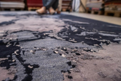 Close-up: carpet surface with a coarse pile and dark blue and gray patterned areas