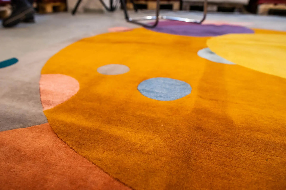 Close-up: carpet with a yellow circle and blue dots on an orange surface