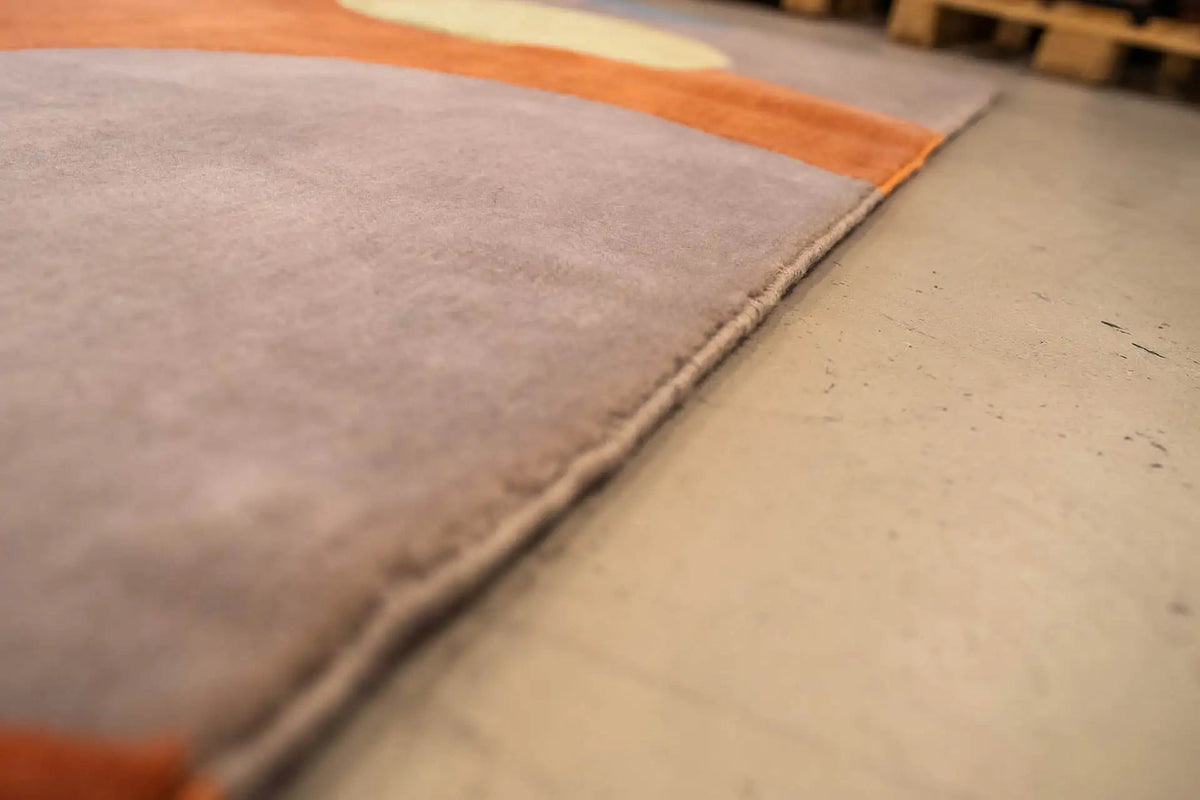 Rug corner with a gray border and a colorful dot pattern along the edge
