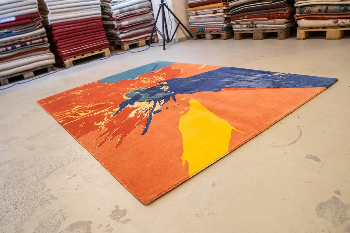 Large-area rug with an abstract color gradient: orange, blue, and yellow in a splash look
