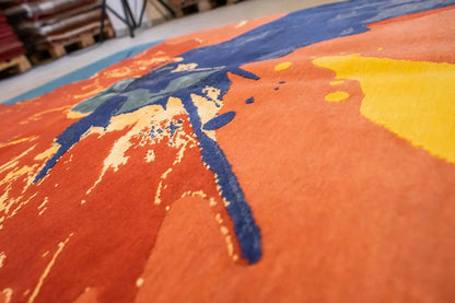 Carpet surface in detail: bold areas of blue, orange and yellow, splash shapes
