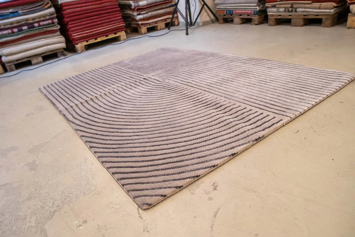 Rectangular rug with a gray field and dark blue concentric line patterns
