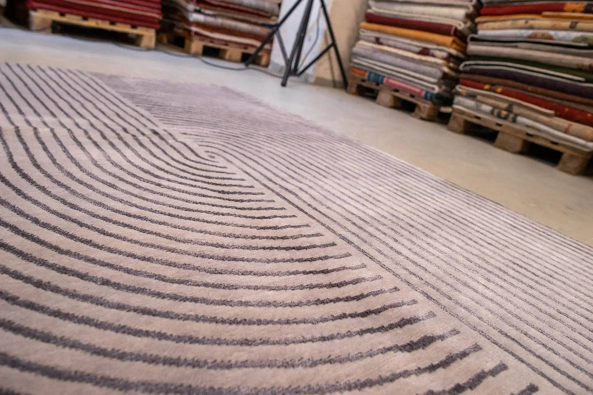 Close-up: gray carpet with dark blue, striped lines and curved contours