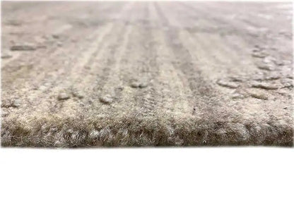 Carpet surface with a dense, mottled gray-beige pile texture