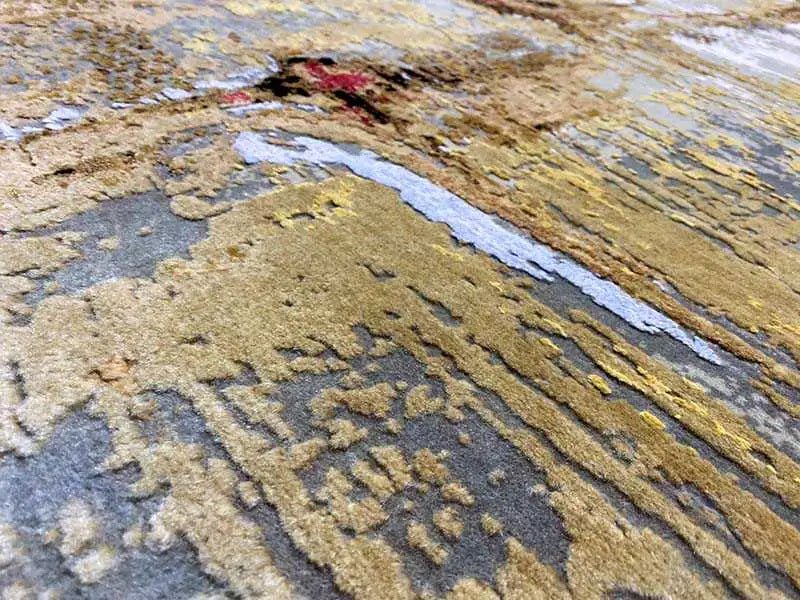 Carpet detail with a blue background, yellow and beige stripes, and small red accents