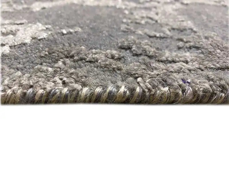 Gray heathered rug with a dense pile surface and a silvery border