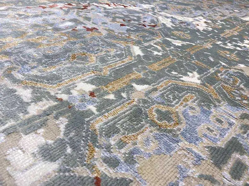 Designer rug with a geometric medallion pattern in blue, gray, and beige