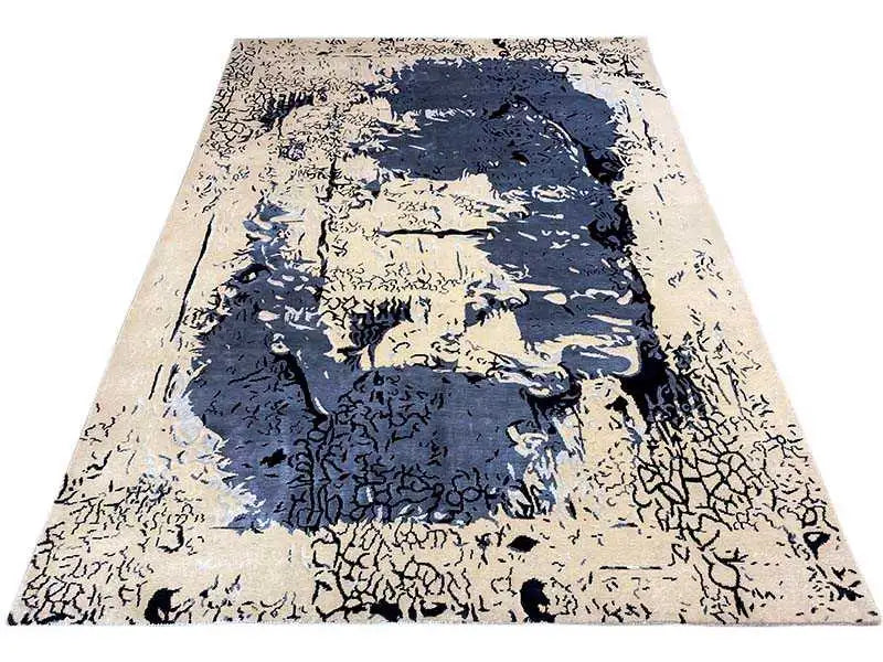 Rectangular designer rug with a blue abstract image and beige flecks