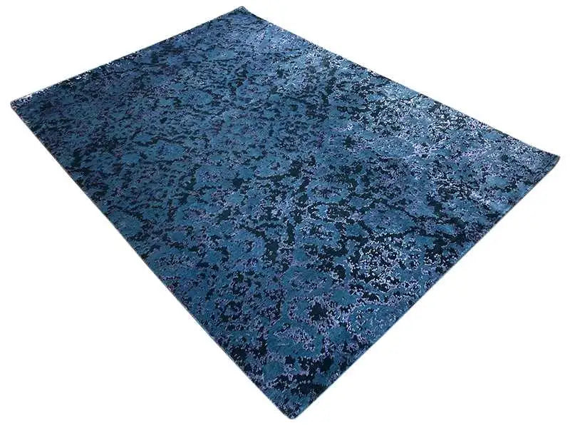 Rug with a blue, mottled vintage pattern and a border around the edge.