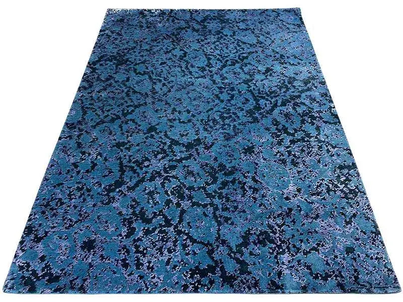 Rectangular, flat-woven rug with a blue-green vintage pattern.