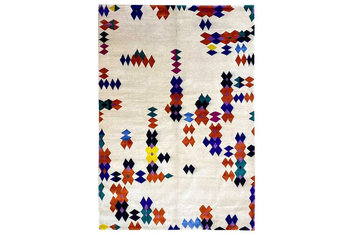 Rug with a geometric patchwork pattern in blue, red, yellow, and purple on a light background.