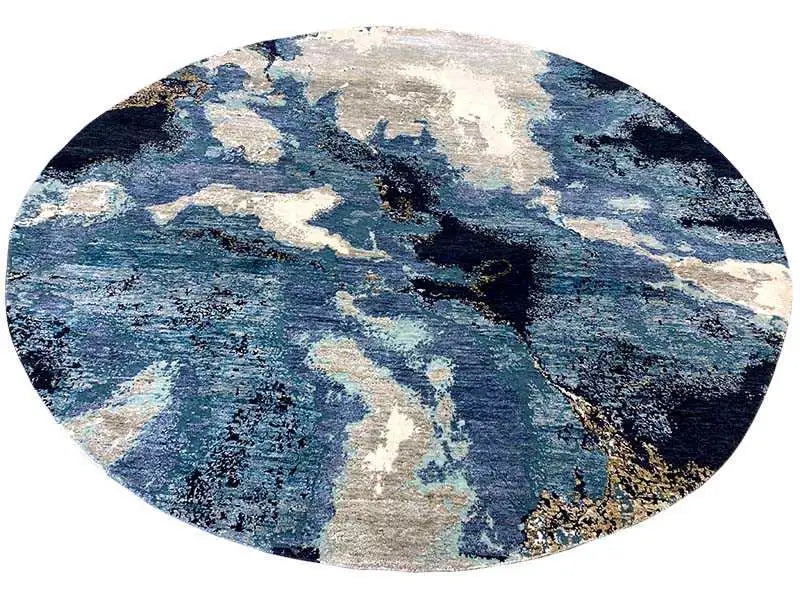 Round designer rug with bold blue accents and beige spots, evenly circular shape.