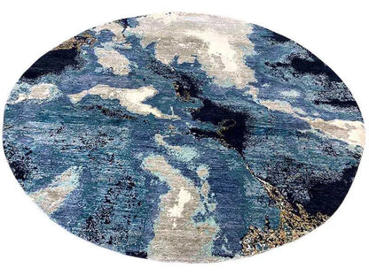Round designer rug with bold blue accents and beige spots, evenly circular shape.