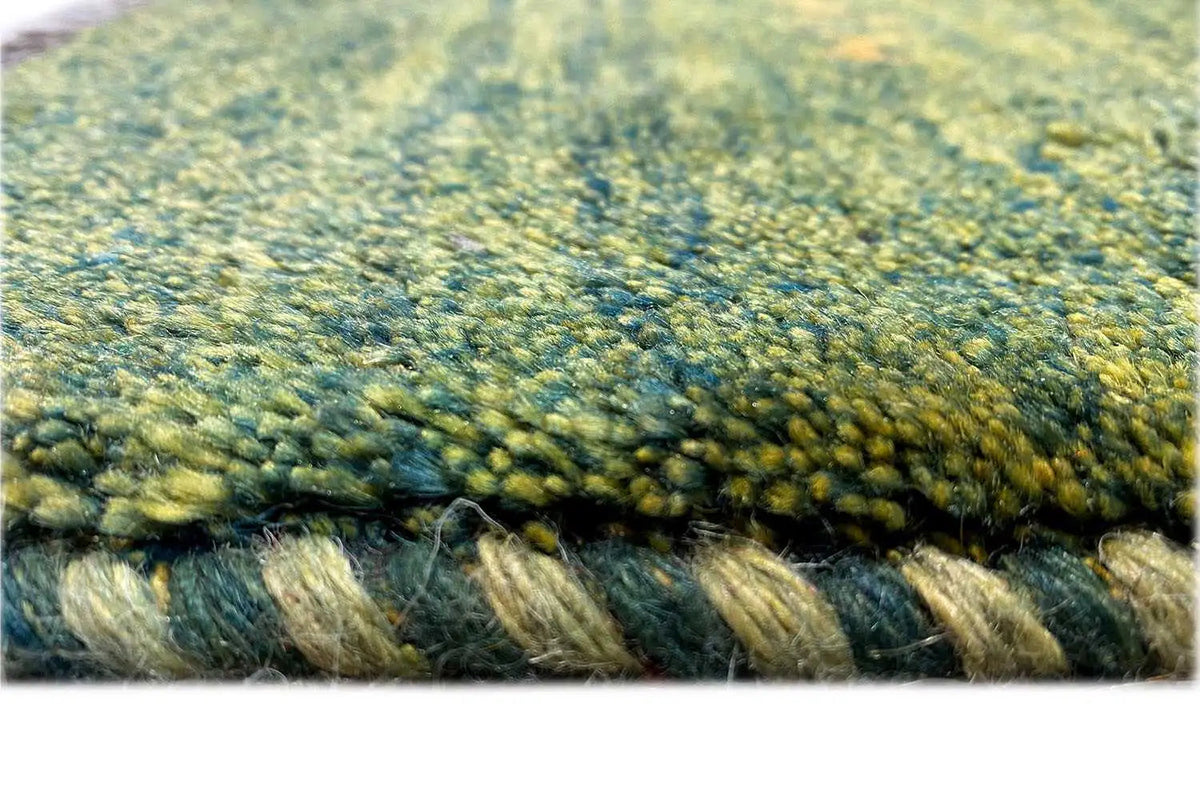 Gabbeh rug close-up, dense pile in green and yellow, visible texture