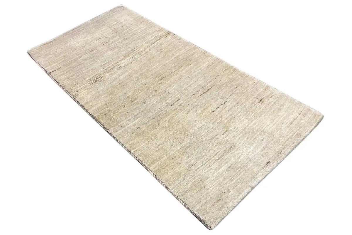 Rectangular light beige Gabbeh rug with a subtle linear pattern, slightly diagonal
