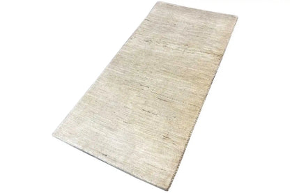 Light beige rectangular Gabbeh rug with an even linear pattern and texture