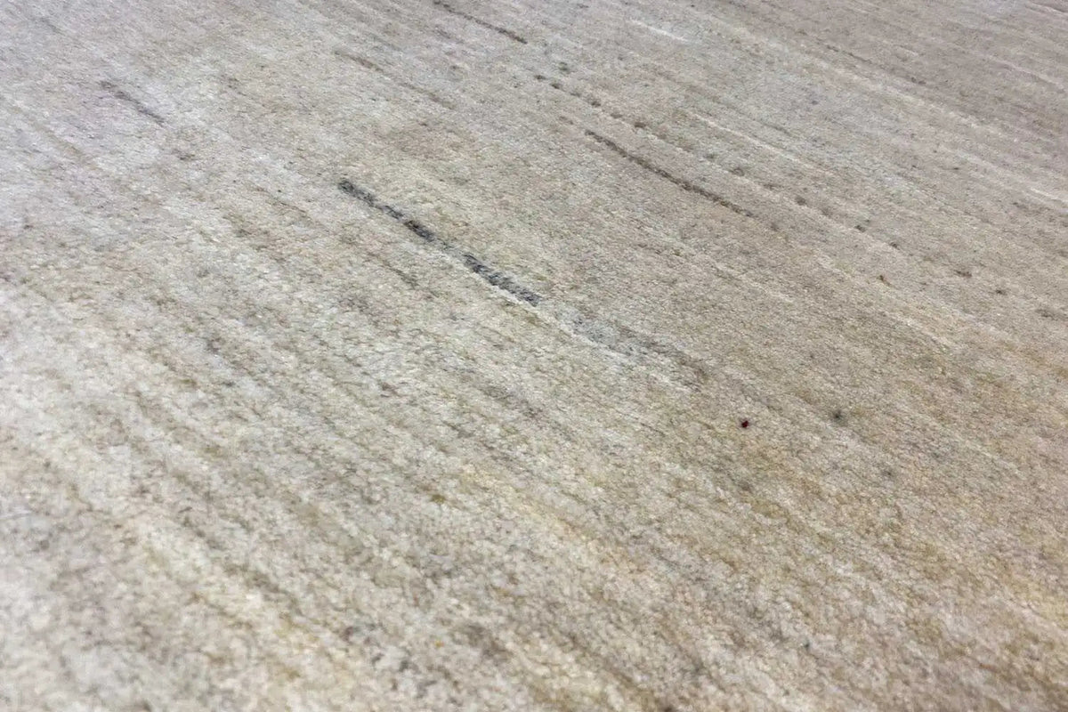 Surface of a light beige Gabbeh rug with fine, parallel lines